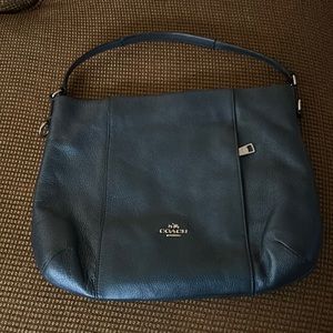 Blue leather coach bag with a crossbody strap, zipper closure